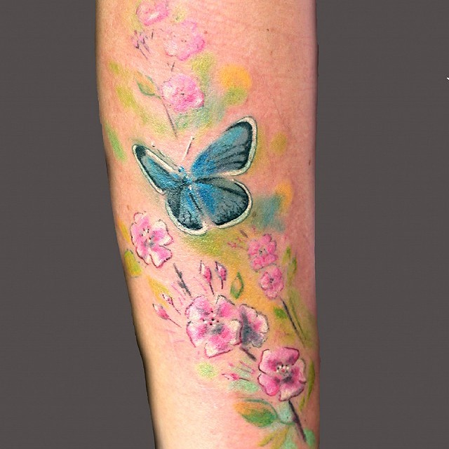 Butterfly and flowers tattoo on lower arm